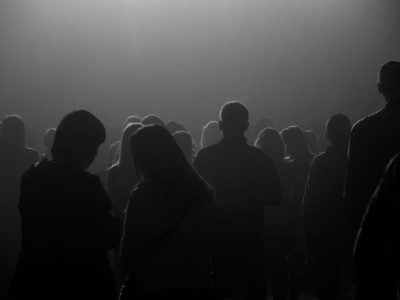 Backlit silhouettes of people in the smoky gloomy space