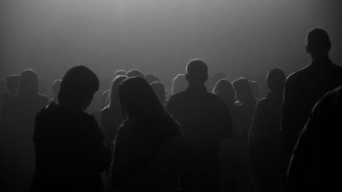 Backlit silhouettes of people in the smoky gloomy space