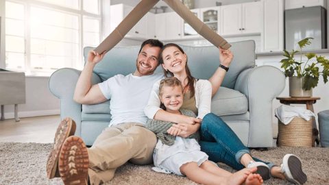 Happy family, portrait and roof with daughter for safety, security or property investment at home. Mother, father and young child or kid with smile on floor for shelter, apartment or house together.