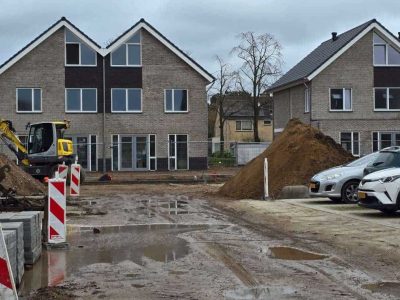 Nieuwe woningbouw in Putten onder constructie met bouwmaterialen en voertuigen.