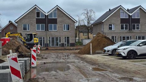 Nieuwe woningbouw in Putten onder constructie met bouwmaterialen en voertuigen.