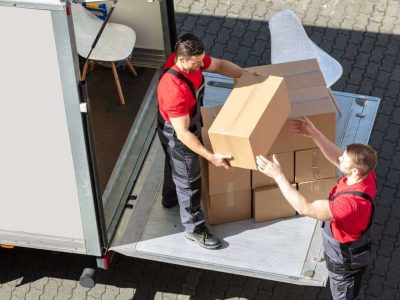 An Overhead View Of A Male Movers Unloading The Cardboard Boxes Form Truck On Street