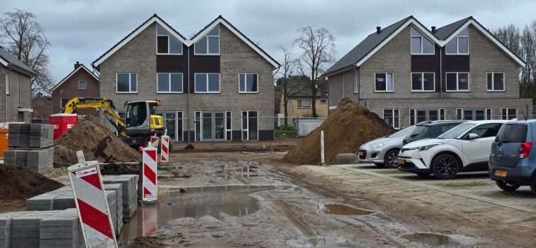Nieuwe woningbouw in Putten onder constructie met bouwmaterialen en voertuigen.